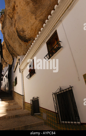 Weiße Häuser unter einem massiven Felsüberhang in Setenil de las Bodegas, Andalusien, Spanien. Traditionelle enge Straße und spanische Architektur. Stockfoto