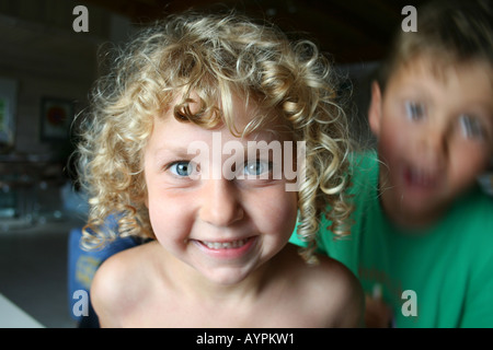 Blauäugige Mädchen spielen mit ihrem Bruder Stockfoto