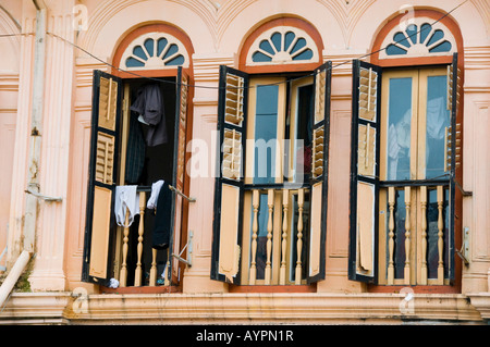 Drei Fenster mit Fensterläden in der zweiten Geschichte Wohnung in Singapur Stockfoto