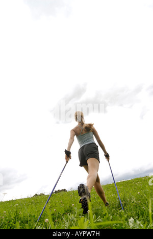 Junge Frau, die Nordic-walking (Skiwandern) Stockfoto