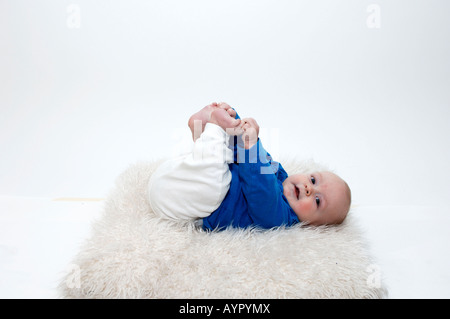 Vier Monate altes Baby junge packte seine Füße Stockfoto