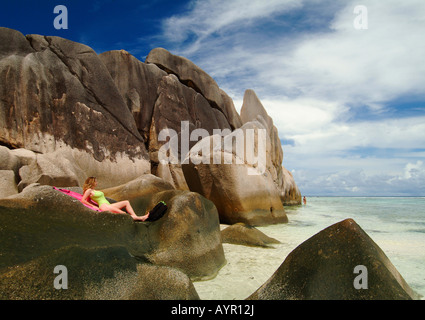 Frau, die Verlegung auf Felsen, Anse Source S'Argent Strand, La Digue Island, Seychellen, Afrika Stockfoto