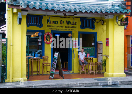 Junger Mann sitzt auf der Terrasse der Bar in Singapur Stockfoto