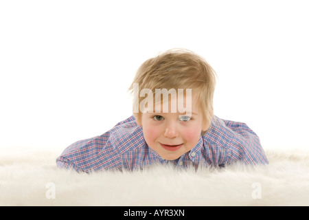 Zwei-jähriger Junge auf fuzzy Teppich Verlegen Stockfoto