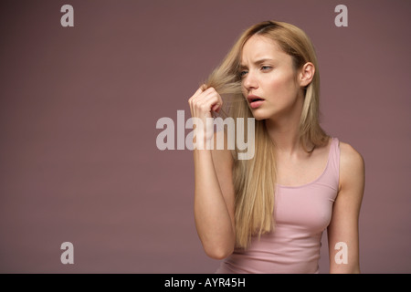 Junge blonde Frau unglücklich über Spliss der blonde lange Haare Stockfoto