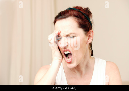 Frau mittleren Alters mit Hand an ihre Stirn Stockfoto