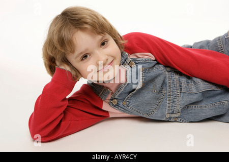 Acht-jährige Mädchen auf dem Boden liegend Stockfoto