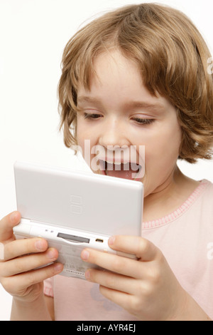 Acht-jährige Mädchen spielen mit ihrem Pocket PC Stockfoto