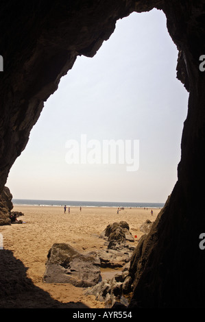 Blick von einer Höhle in Three Cliffs bei Ebbe, Gower Peninsula in der Nähe von Swansea, West Glamorgan, Wales, Großbritannien. Sandstrand und Felsen sichtbar. Stockfoto