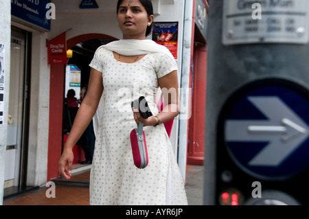 Indische Frau zu Fuß auf einem Bürgersteig in Little India Singapur Stockfoto