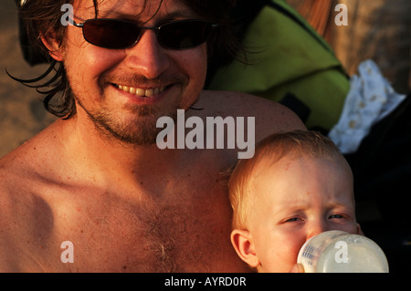 Niederländische Antillen Curacao einen jungen bekommen eine Flasche am Strand von seinem Vater Stockfoto