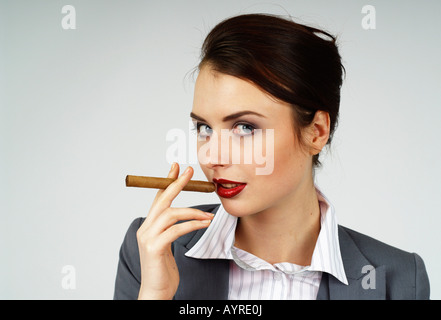 Junge Unternehmerin, Managerin, raucht eine Zigarre Stockfoto