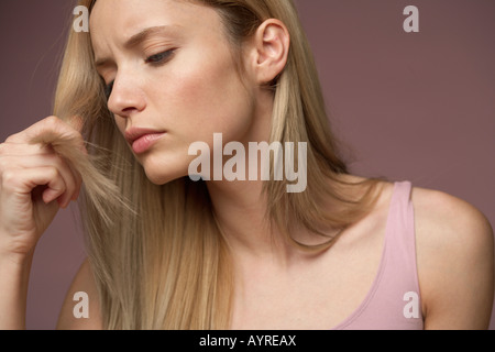 Junge blonde Frau unglücklich über Spliss der blonde lange Haare Stockfoto