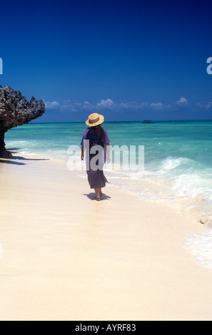 Frau Touristen zu Fuß am Strand von Nungwi an der Nordwestküste der Insel Sansibar, Tansania Stockfoto