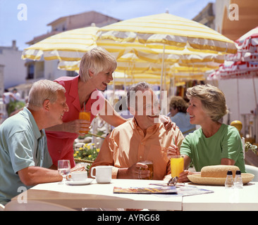 zwei ältere Ehepaare im Rentenalter im Urlaub trinken am Straßencafé Stockfoto