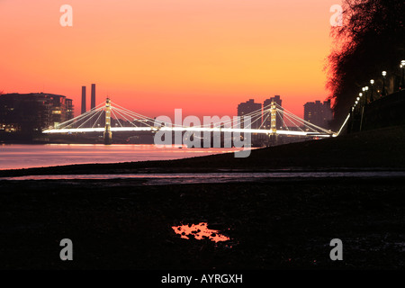 Albert-Brücke bei Sonnenuntergang, gesehen von der Themse bei Chelsea Embankment, London, England, UK Stockfoto