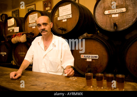 Kellner Juan halten Register mit Kreide auf die Leiste in Antigua Casa de Guardia, Fässer Sherry hinter ihm, Bodega in Málaga, Andalus Stockfoto