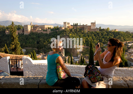 Touristen fotografieren gegenseitig am Mirador de San Nicolas Aussichtspunkt, der Alhambra in der Ferne, Granada, Andalusien, Stockfoto