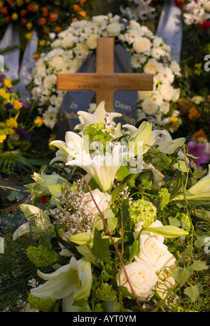 Frischen Grab geschmückt mit unzähligen Blüten auf einem Friedhof in Deutschland Stockfoto