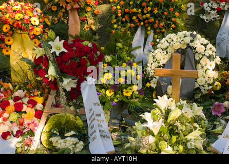 Frischen Grab geschmückt mit unzähligen Blüten auf einem Friedhof in Deutschland Stockfoto