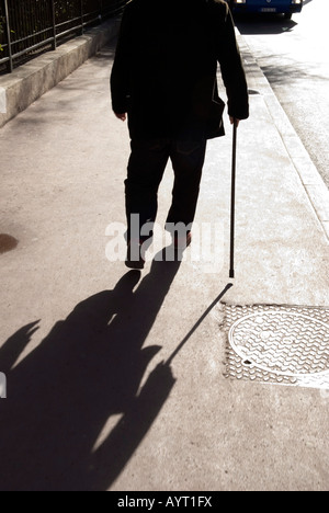 eine verkürzte Ansicht eines alten Mannes zu Fuß entfernt, mit Spazierstock Stockfoto