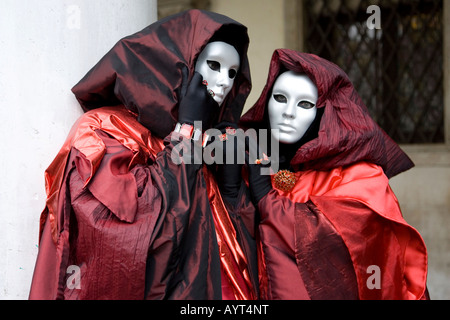 Zwei Personen tragen rot und schwarz Kostüme, Kapuzen Umhänge und Masken, Carnevale di Venezia, Karneval in Venedig, Italien Stockfoto