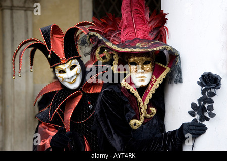 Harlekin (Hofnarr) Kostüm und elegante Dame mit schwarzen rose in der hand, Carnevale di Venezia, Karneval in Venedig, Italien Stockfoto
