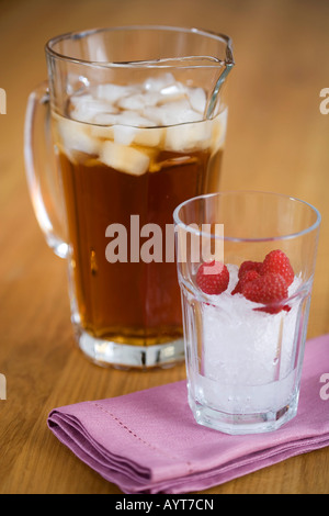 A kann mit Eis-Tee und ein Glas mit Eiswürfeln ein einiges an Himbeeren Stockfoto
