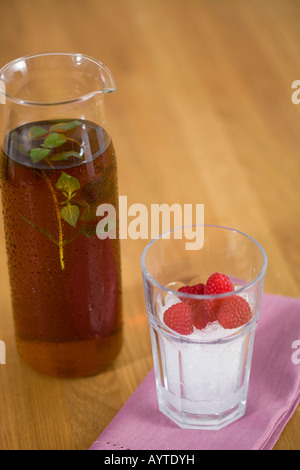 A kann mit Eis-Tee und ein Glas mit Eiswürfeln ein einiges an Himbeeren Stockfoto