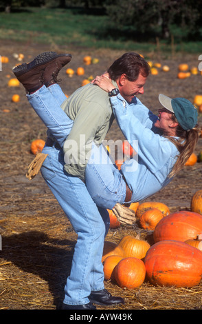 Spielerische Mann und Frau genießen Sie die sonnigen Herbsttag beim Kauf eines Kürbis in ein Bauern-Markt-Feld. Stockfoto