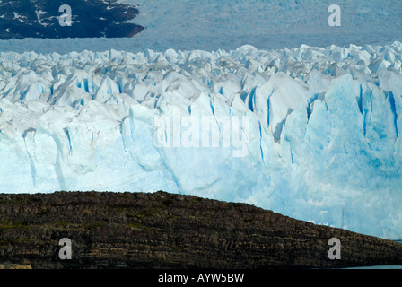 Eine Auffassung der Perito-Moreno-Gletscher, als es bewegt sich langsam vorwärts zu verschlingen die Granitfelsen im Vordergrund Stockfoto