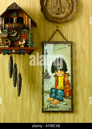 Klebrig Wandbehang einschließlich einer Kuckucksuhr hängen an einem Holz getäfelte Wand Stockfoto