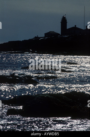 Glitzern Sie Sonne auf den Wellen am felsigen Ufer Beavertail Leuchtturm im Hintergrund Jamestown Rhode Island USA Stockfoto