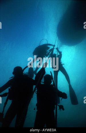 Silhouetten von Taucher Dekomprimierung während hängen an einem Boot Ankerleine an den Dardanellen. WW1 Wracktauchen. Stockfoto