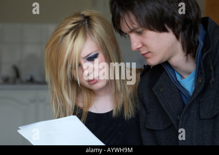 junge Teenager-paar aufmerksam lesen eines Dokuments zusammen in der Küche von ihrem Appartement Stockfoto