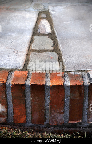 VOR KURZEM LEGTE SPITZEN GELENKE AUSTROCKNEN AUF EINE TERRASSE MIT NATURSTEINPLATTEN UND AUFGEARBEITETEN ROTEN ZIEGELN UK Stockfoto