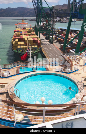 Hintere Deck eines Kreuzfahrtschiffes mit Swimming Pool und ein Containerschiff festgemacht achtern in Lyttelton, Neuseeland Stockfoto