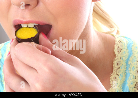Junge Frau Essen, Zitrone und Limette Schokolade Modell veröffentlicht Stockfoto