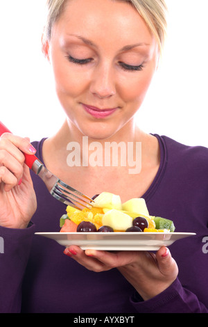 Junge Frau essen Obst Salat Modell veröffentlicht Stockfoto