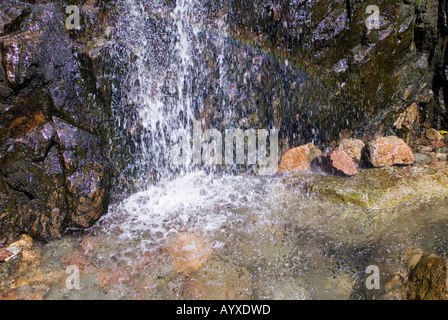 Detail eines kleinen Wasserfalls, die die Wirkung des fließenden Wassers auf den Surround-Felsen Stockfoto