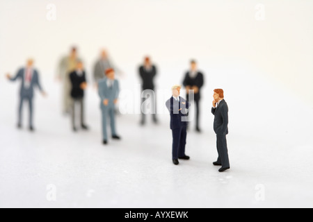 Zwei Geschäftsleute Figuren sprechen, andere, im Hintergrund Stockfoto