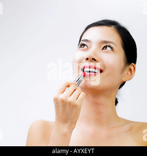 das Gesicht einer Frau mit einem Lippenstift mit Blick auf den Himmel gelegt Stockfoto
