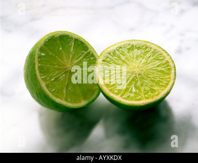 AUFNAHME EINER GANZEN LIMETTE HALBIEREN AUF MARMOR OBERFLÄCHE Stockfoto