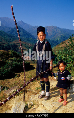 Schwarze h ' Mong Hill Tribe Frau und ein Kind mit Zuckerrohr Commig vom Markt Sapa. Sapa. Nord-West-Vietnam Stockfoto