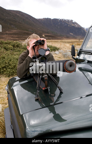 Alladale Stalker David Clark beobachtete Rothirsch neben Landrover, Alladale Estate, Schottland Stockfoto