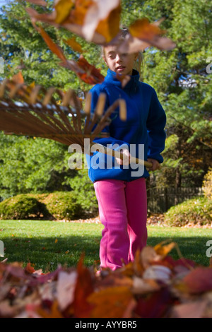 Kind Laubrechen in ihrem Hinterhof Stockfoto
