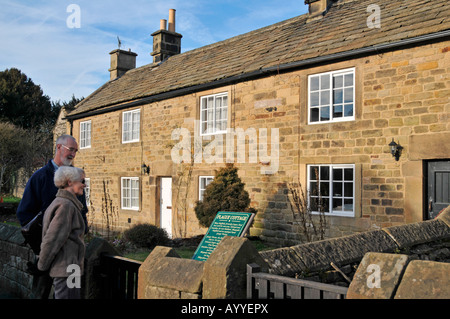 Elderley paar auf der Suche in den Pest-Cottages in Eyam Dorf National Park Derbyshire Stockfoto