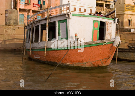 Altes Touristenboot in einem Ghetto am Ufer des Ganges bei Sonnenaufgang in Varanasi, Uttar Pradesh, Indien. Stockfoto