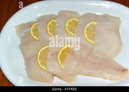 Ohne Knochen ohne Haut und ungekocht Rohteile Heilbutt Filet mit Zitronenscheiben auf Platte Stockfoto