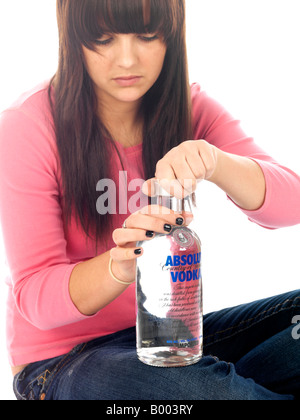 Junge Minderjährige Teenager sitzen auf dem Boden allein Erleben zugefügt Alkoholmissbrauch Alkohol trägt ein rosa Top und Blue Denim Jeans Stockfoto